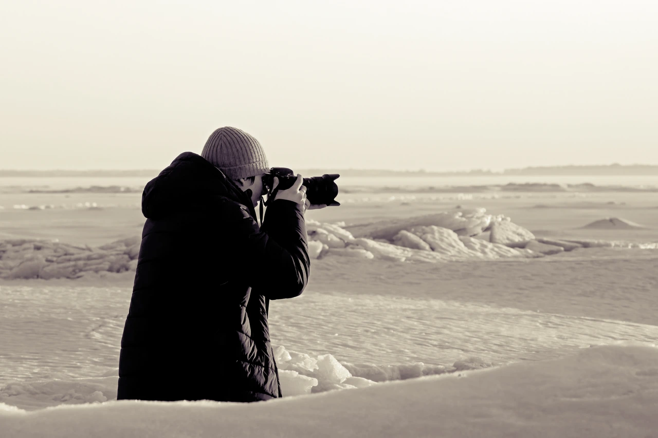 Photographing beside a frozen, snow-covered shoreline.